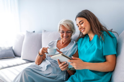 senior woman and caregiver reading