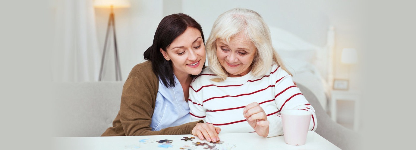 caregiver and senior woman playing puzzles